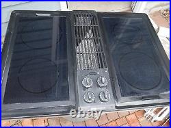 Jenn air downdraft cooktop with black glass burners and grill unit